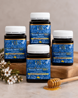 Assorted sizes of AB’s raw Australian honey in plastic tubs with yellow and white lids displayed on