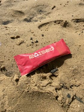 Raised collagen protein bars in Salted Caramel, Chocolate Almond and Açaí flavours on wooden table