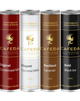 Hands holding Cafeda Vietnamese iced coffee cans alongside fresh baguette sandwiches, showcasing pre