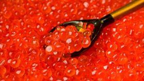 Harigon Gourmet Foods black caviar and red caviar in crystal bowls with crepes on a white tablecloth