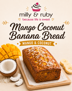 Three loaves of Milly & Ruby banana bread arranged on a marble surface with fresh bananas, a mango,