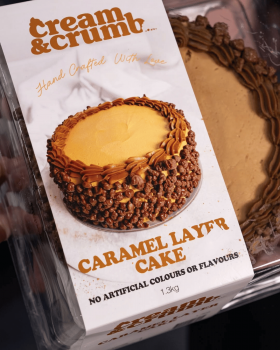 Cream & Crumb family-size layer cakes in clear clamshell packaging displayed in a supermarket refrig