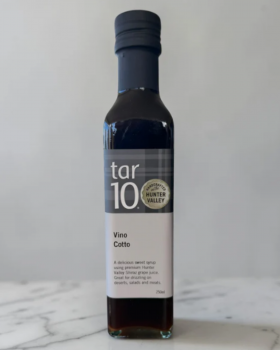 tar10 caramelised balsamic vinegar being drizzled over cheese and bread on a charcuterie board