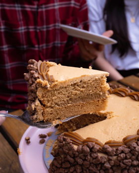Cream & Crumb family-size layer cakes in clear clamshell packaging displayed in a supermarket refrig