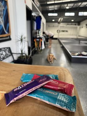 Raised collagen protein bars in Salted Caramel, Chocolate Almond and Açaí flavours on wooden table