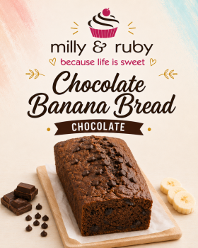 Three loaves of Milly & Ruby banana bread arranged on a marble surface with fresh bananas, a mango,