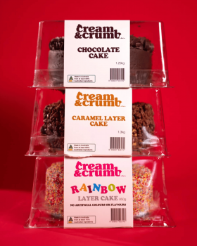 Cream & Crumb family-size layer cakes in clear clamshell packaging displayed in a supermarket refrig