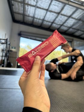 Raised collagen protein bars in Salted Caramel, Chocolate Almond and Açaí flavours on wooden table