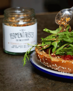 Contract manufacturing image showing a bottle of red sauce being poured against a black background.