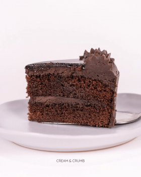 Cream & Crumb family-size layer cakes in clear clamshell packaging displayed in a supermarket refrig