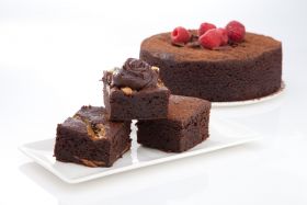 Gluten-free layered cake by Melinda’s Gluten Free Goodies, featuring a frosted sponge cake displayed