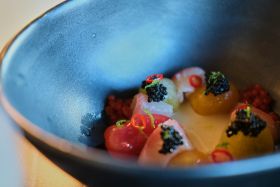 Harigon Gourmet Foods black caviar and red caviar in crystal bowls with crepes on a white tablecloth
