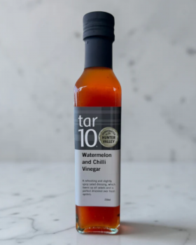 tar10 caramelised balsamic vinegar being drizzled over cheese and bread on a charcuterie board