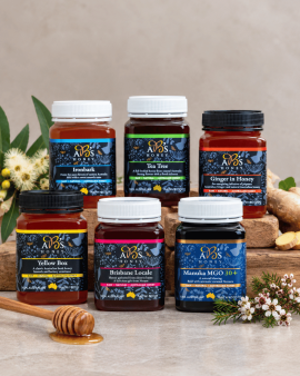 Assorted sizes of AB’s raw Australian honey in plastic tubs with yellow and white lids displayed on