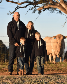 Close-up of a tender Glanmire Murray Greys beef slice held on a fork against a black background.
