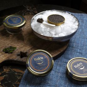 Harigon Gourmet Foods black caviar and red caviar in crystal bowls with crepes on a white tablecloth