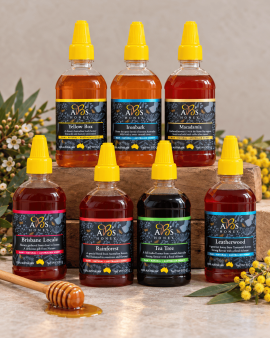 Assorted sizes of AB’s raw Australian honey in plastic tubs with yellow and white lids displayed on